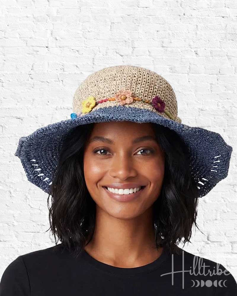 Woman wearing a colorful straw hat with a white background, featuring the 'Hilltribe' brand.