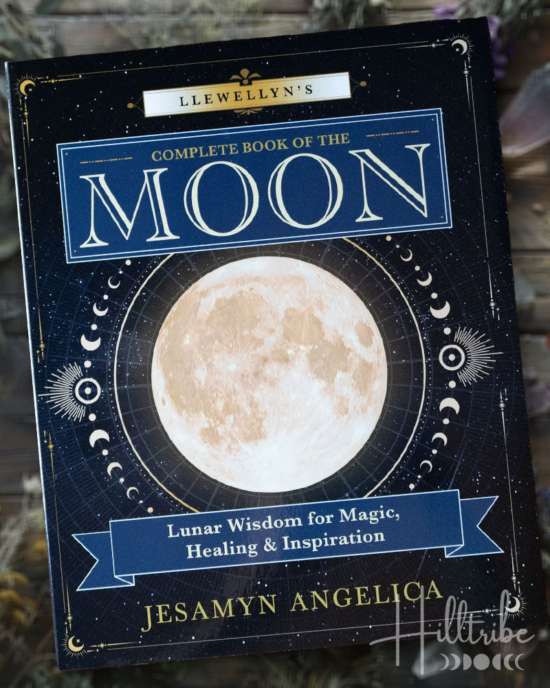 Book titled 'Llewellyn's Complete Book of the Moon' by Jesamyn Angelica on a wooden surface.