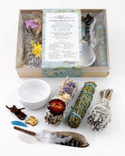 Sacred smudge kit with incense sticks, feather, and bowl on a white background