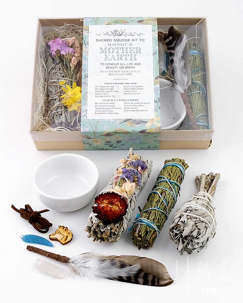Sacred smudge kit with incense sticks, feather, and bowl on a white background