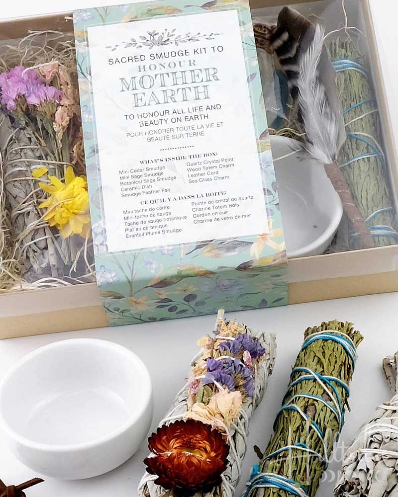 Sacred smudge kit for Mother Earth with incense sticks, flowers, and a bowl on a white surface.
