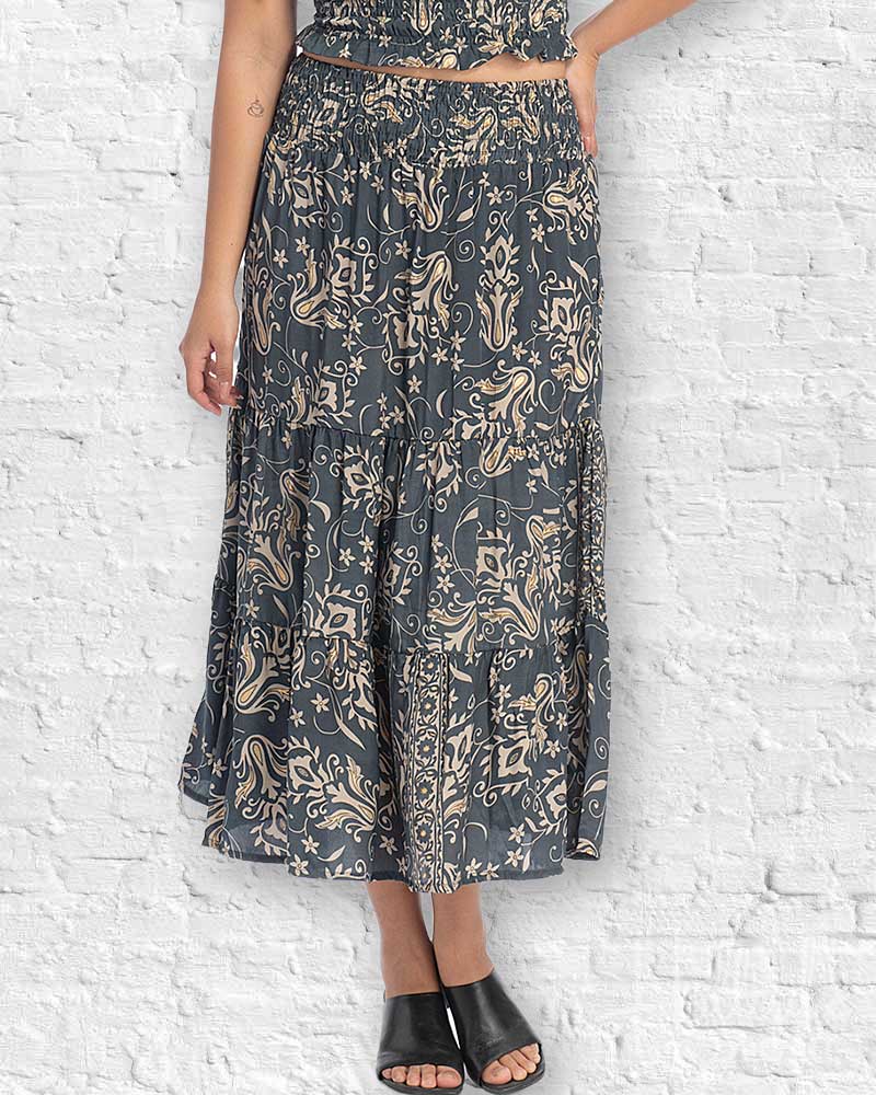 Person wearing a patterned outfit against a white brick wall.