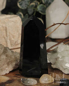 Black crystal tower surrounded by other crystals on a wooden surface