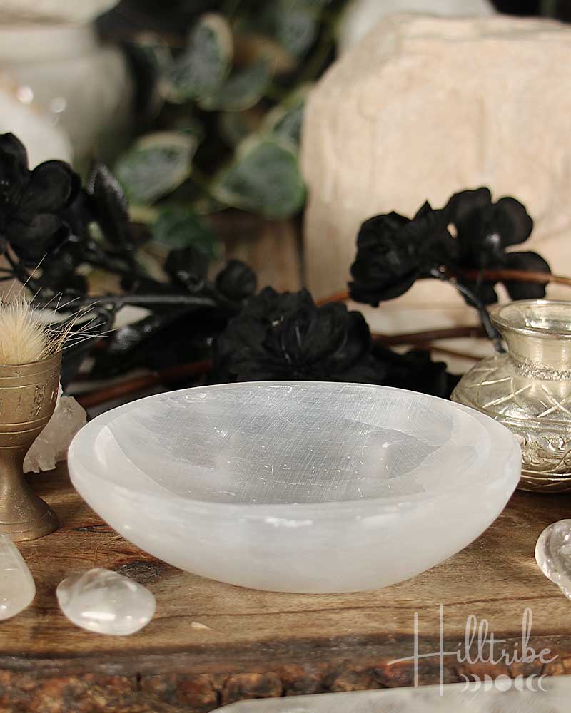 Selenite Crystal bowl on a wooden surface with blurred background