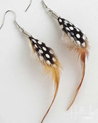 Feather earrings with black, white, and brown feathers on a white background