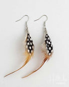 Feather earrings with black and white pattern on a light gray background