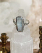 Silver ring with a blue stone on a crystal pedestal with a blurred background