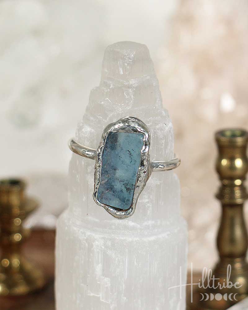 Silver ring with a blue stone on a white crystal, Halltribe brand visible