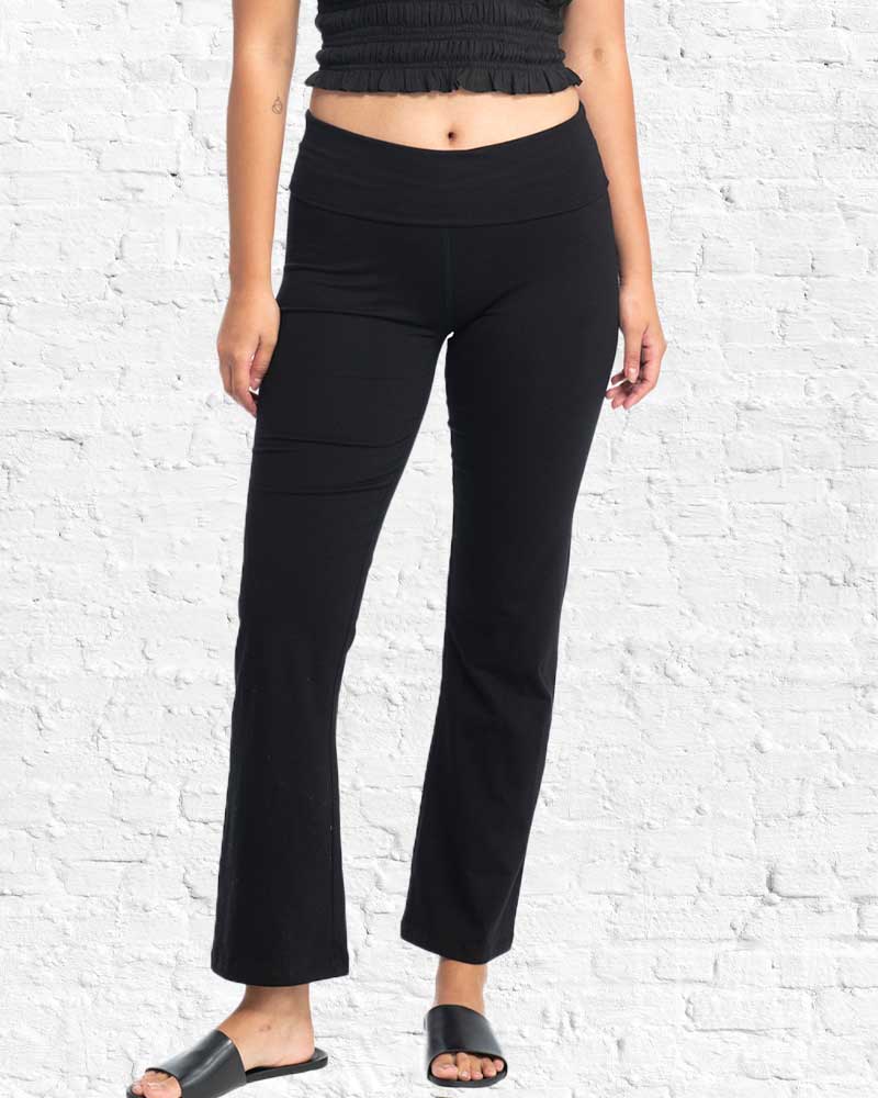 Person wearing black pants against a white brick wall