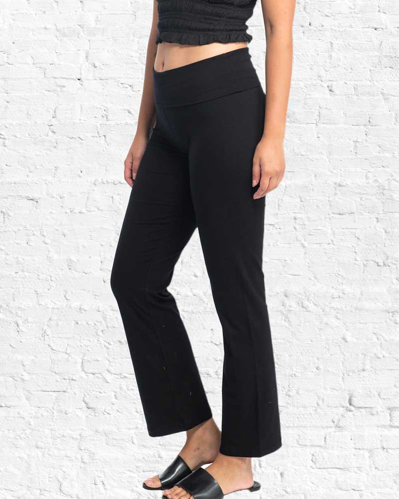 Person wearing black pants against a white brick wall