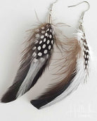 Feather earrings with black, white, and brown feathers on a light gray background