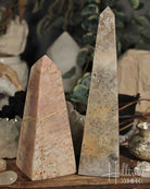 Rose Pink Amethyst stone obelisks on a wooden surface with a blurred background