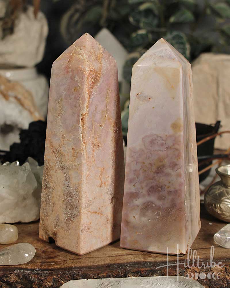 Rose Pink Amethyst stone obelisks on a wooden surface with a blurred background