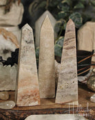 Rose Pink Amethyst stone obelisks on a wooden surface with a blurred background