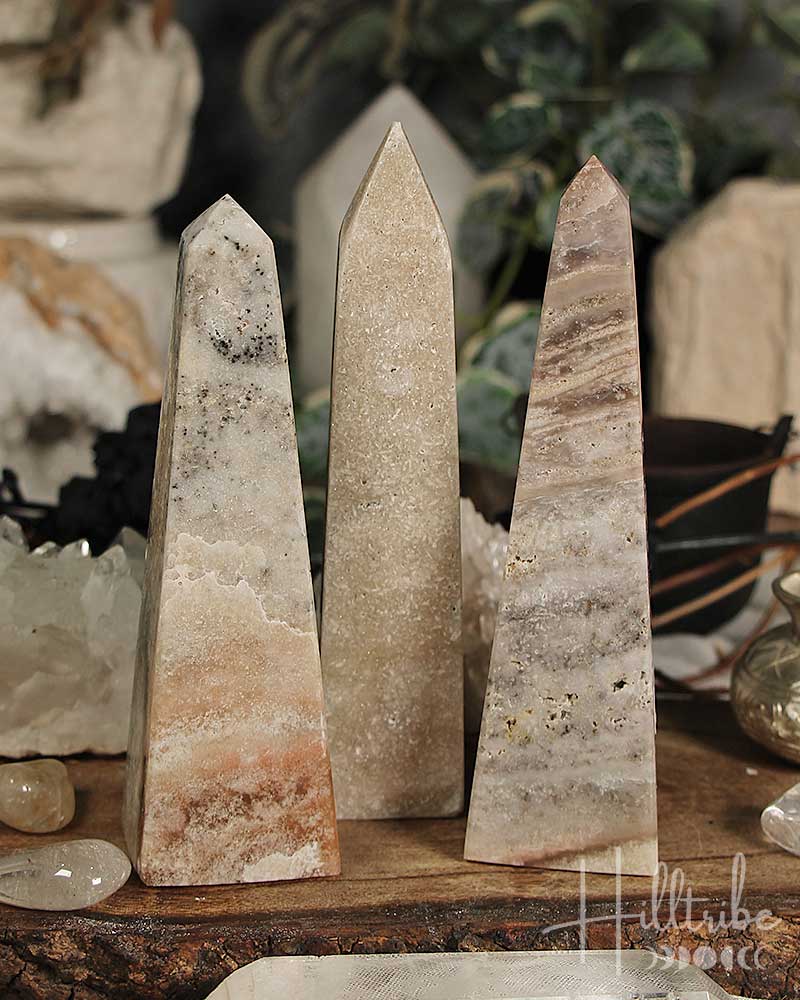 Rose Pink Amethyst stone obelisks on a wooden surface with a blurred background