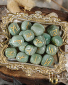Green Aventurine stones with gold runes on a decorative tray