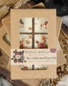 Box of 'Be Celebrated Wax Melt' by Simmer and Co. on a wooden surface with strawberries.