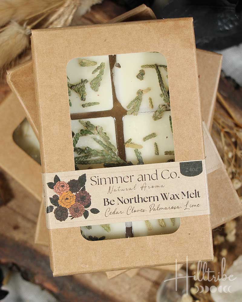 Packaged wax tarts with cedar natural elements on a wooden surface