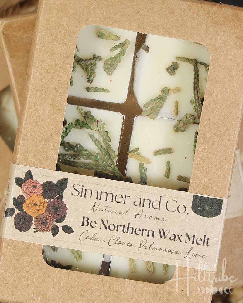 Packaged wax tarts with cedar natural elements on a wooden surface