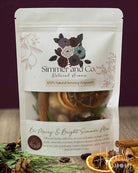 A stand-up pouch of Simmer and Co. Natural Aroma Poppyseed spice mix, labeled 'Be Merry & Bright Simmer Mix'.