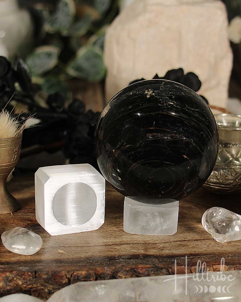 Black crystal ball and white crystal blocks on a wooden surface with blurred background
