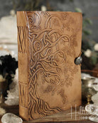 Brown leather journal with embossed design on a blurred background