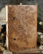 Brown leather journal with embossed designs on a blurred background