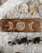 Triple Moon Tarot Card Holder with moon phases on a textured surface with decorative elements.