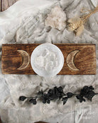 Triple Moon Tarot Card Holder with moon designs and a crystal on a textured surface.