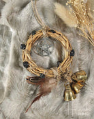 Decorative wreath with pentacle pendant, feathers, and bells on a fur background